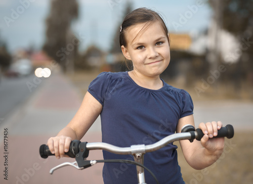 Cute girl is sitting on bicycle