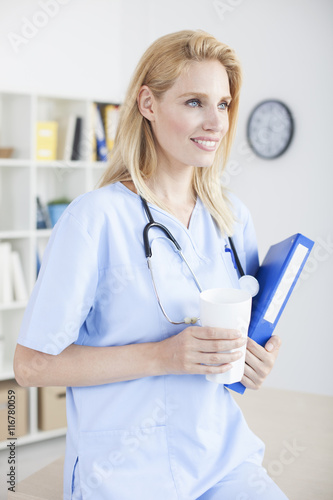 Young female doctor and practitioner working at desk 