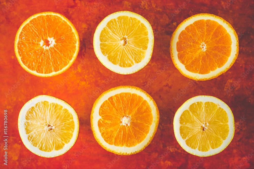Obraz premium Lemon and orange slices on the terracotta background horizontal