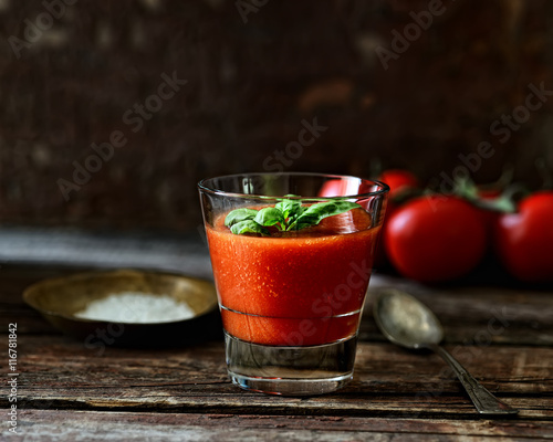 Fresh organic tomato juice on a wooden background