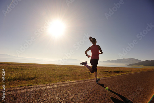 young fitness woman runner running on sunrise seaside trail