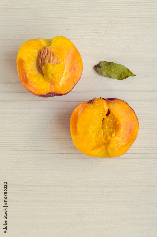 Ripe peaches on white wooden background