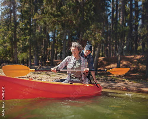 Картината върху платно Mature couple having fun at the lake with kayak