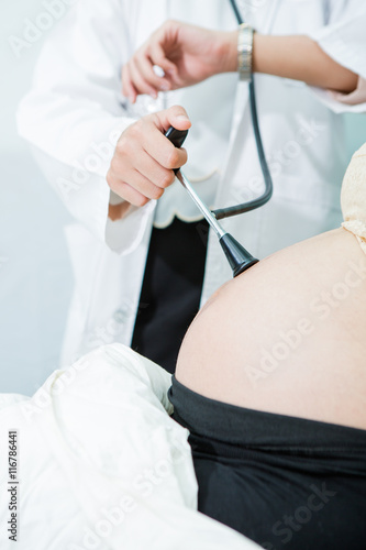 Doctor use stethoscope check fetal heart sound to pregnancy woman