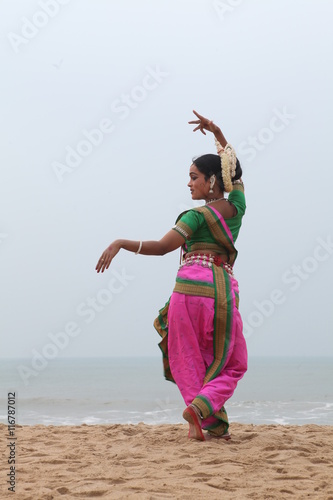 odissi is one of the classical dance forms of india.here the dancer poses at a beach