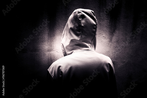 Back side of mysterious woman wearing hoodie hiding in the dark,Scary background for book cover