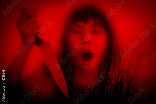 Quadro su tela Horror scene of woman with knife behind stained or dirty window glass,Serial kil