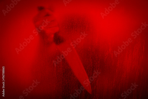 Horror scene of woman with knife behind stained or dirty window glass,Serial killer or violence concept background