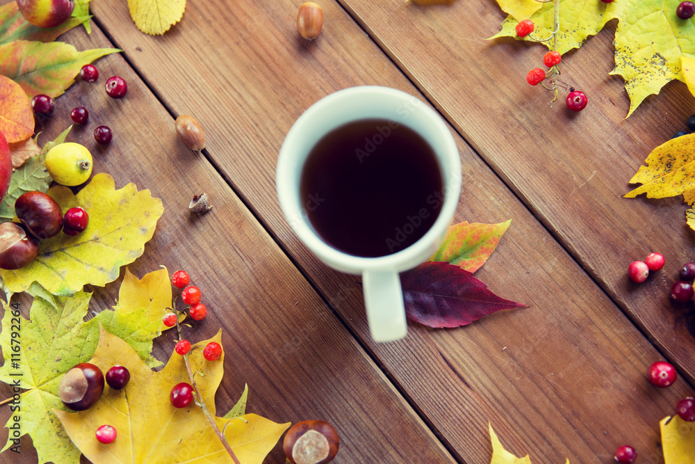 close up of tea cup on table with autumn leaves