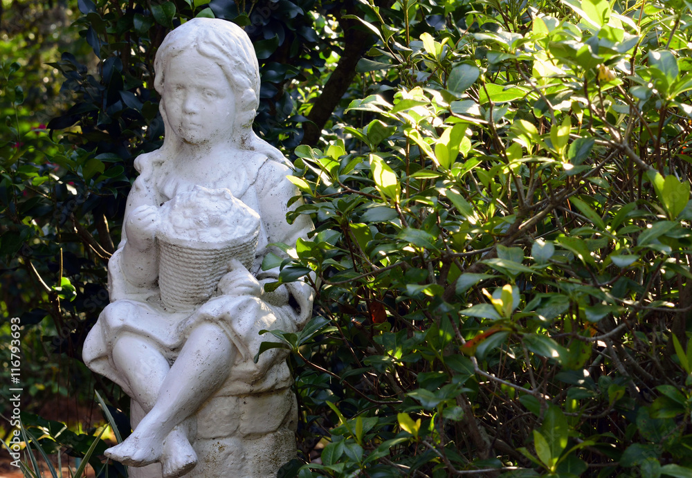 Statue of a little girl in a botanical garden