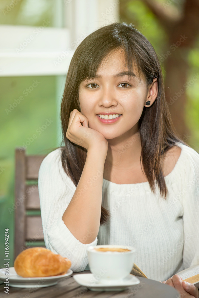 asian woman drink coffee and reading book in garden asian woman drink coffee and reading book in garden