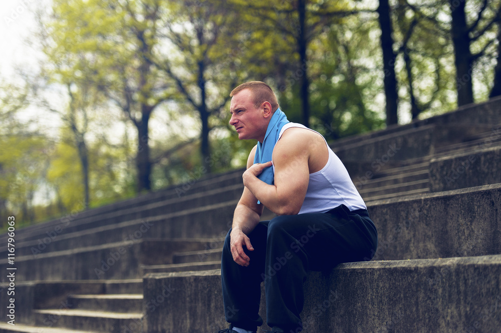 Active man resting after workout with towel. Active man resting after workout with towel.