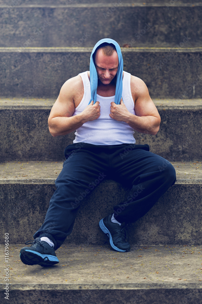 Fototapeta premium Active man resting after workout with towel.