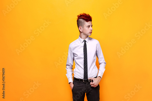 Portrait of displeased teen punk in shirt and tie looking away with hands in pockets.Isolated photo