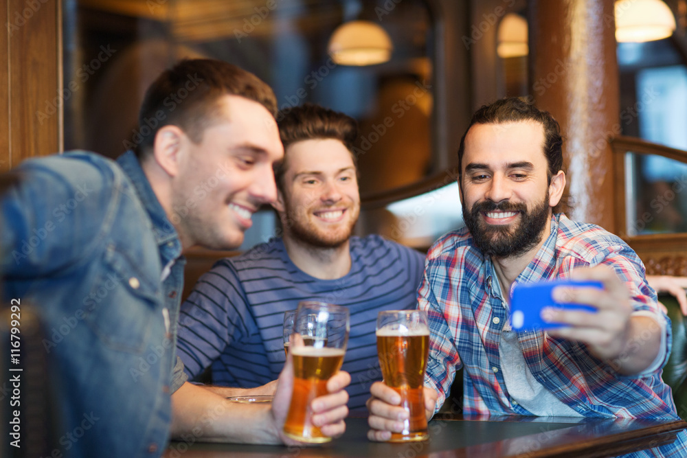 friends taking selfie and drinking beer at bar