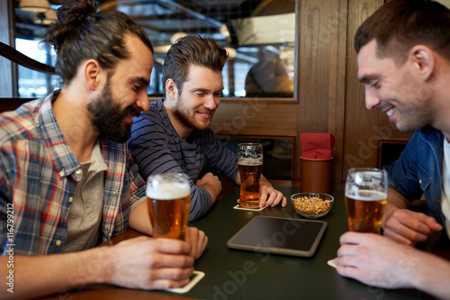 male friends with tablet pc drinking beer at bar