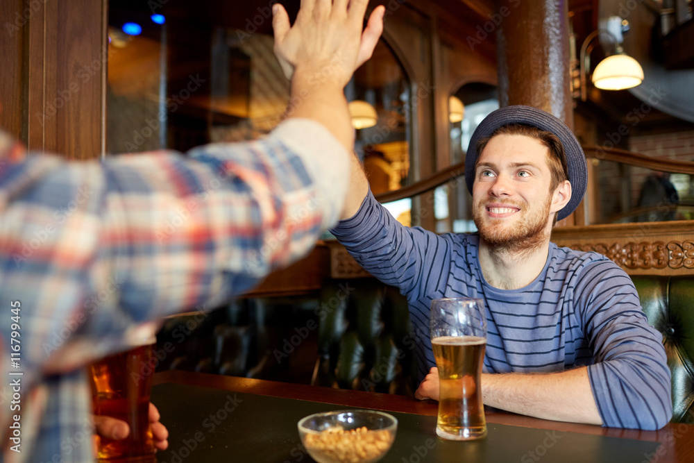 happy male friends making high five at bar or pub
