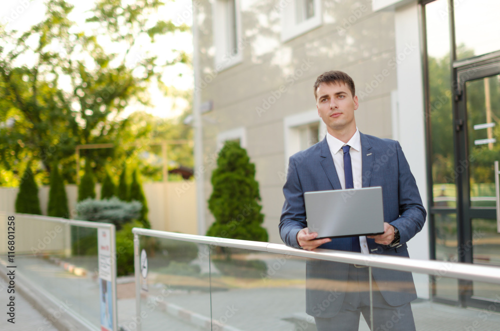 Case in a way. Confident and successful businessman holding a laptop. Case in a way. Confident and successful businessman holding a laptop.