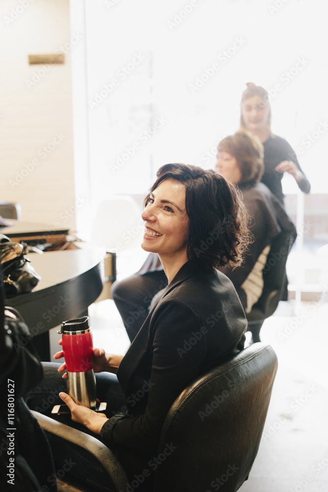 A client sitting in a hair salon chair. Stock Photo Adobe Stock