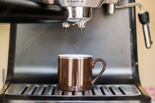 espresso machine making coffee and pouring in a brown cup