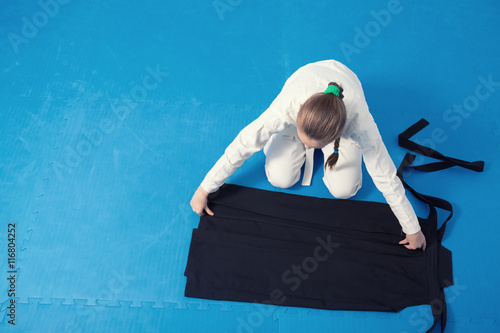 An aikidoka girl folding her hakama for Aikido training photo