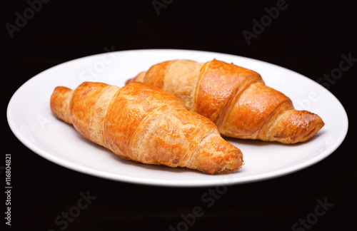 Two croissants on white plate 