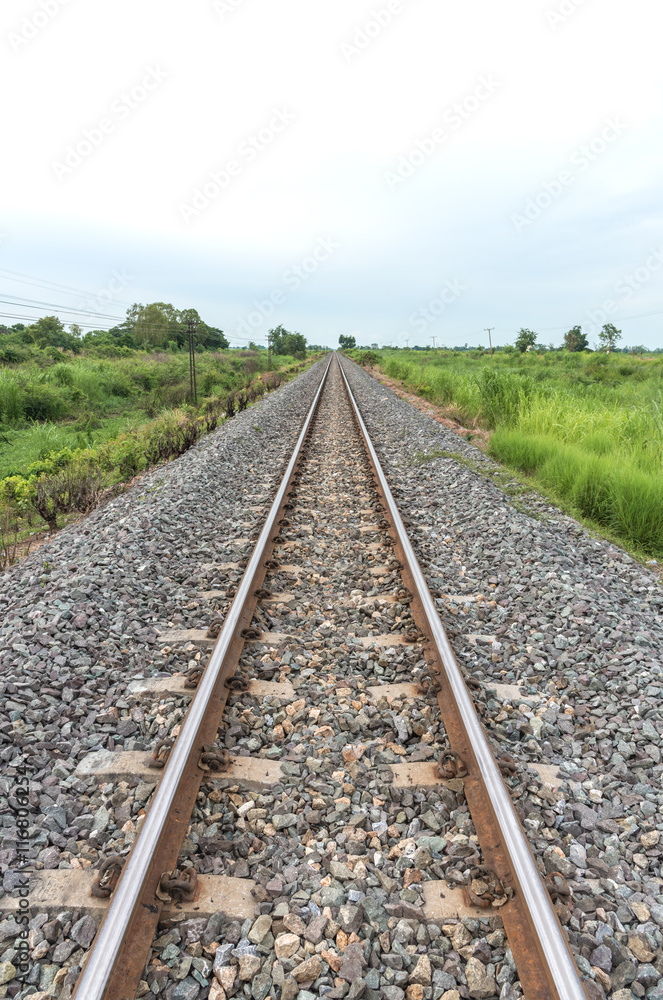 Long straight railroad on concrete sleepers in a rural