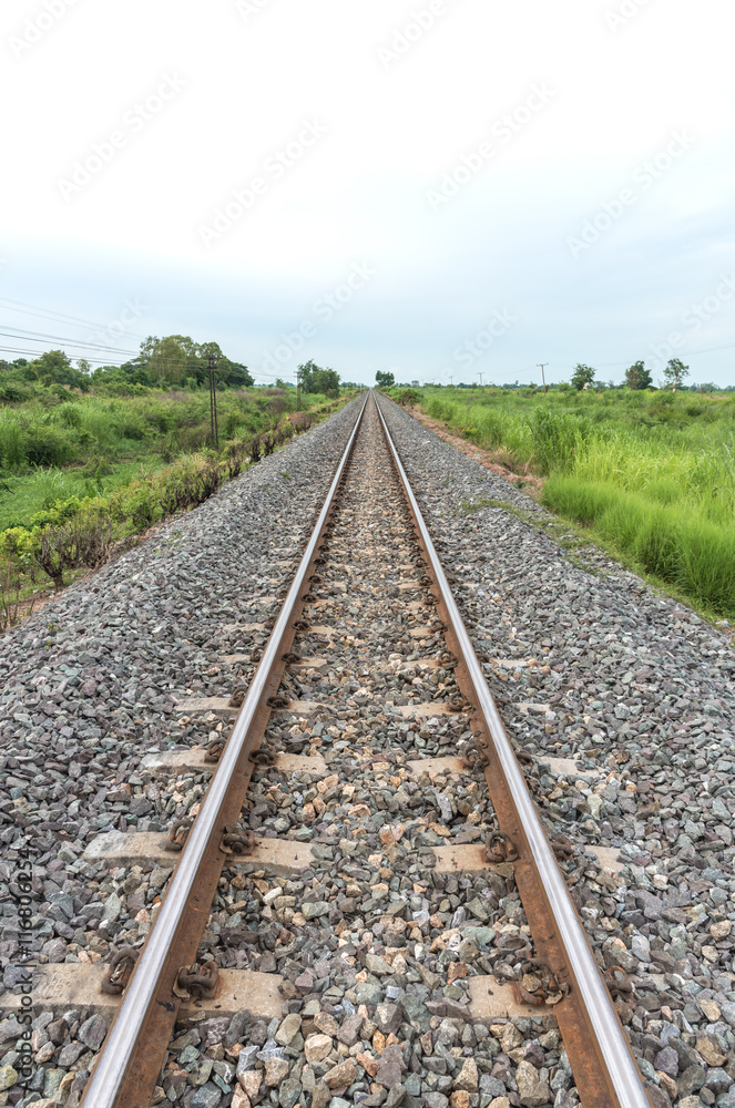 Long straight railroad on concrete sleepers in a rural Long straight railroad on concrete sleepers in a rural