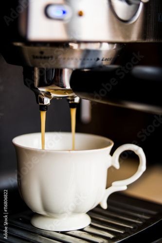 espresso machine making coffee and pouring in a white cup