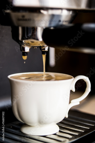 espresso machine making coffee and pouring in a white cup