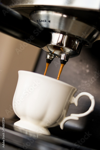 espresso machine making coffee and pouring in a white cup