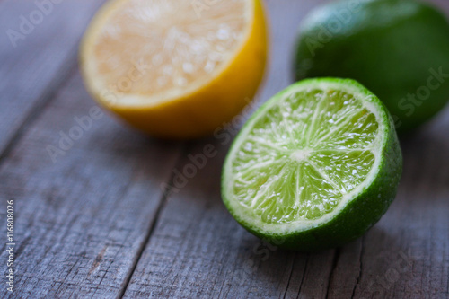 half a lemon and lime on wooden background