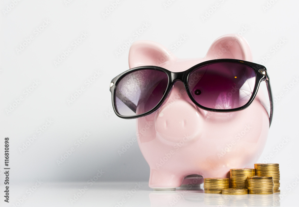 Piggy bank with sunglasses and coins on the white background Piggy bank with sunglasses and coins on the white background