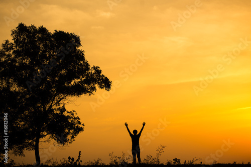Silhouette of man and beautiful sky sunset. hand up of success.