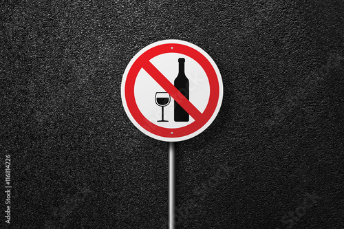 Road sign of the circular shape on a background of asphalt. No alcohol. The texture of the tarmac, top view.