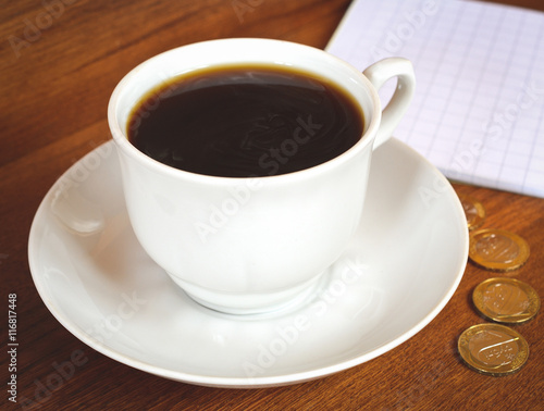 Coffee cup and saucer on a wooden table. Dark background.