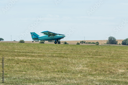 Small tow plane landing on a grassy airfield