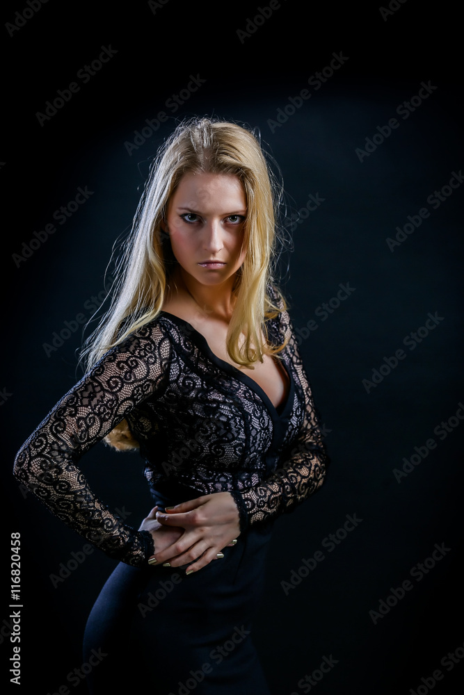 blonde girl on a black background in a dark guipure dress blonde girl on a black background in a dark guipure dress