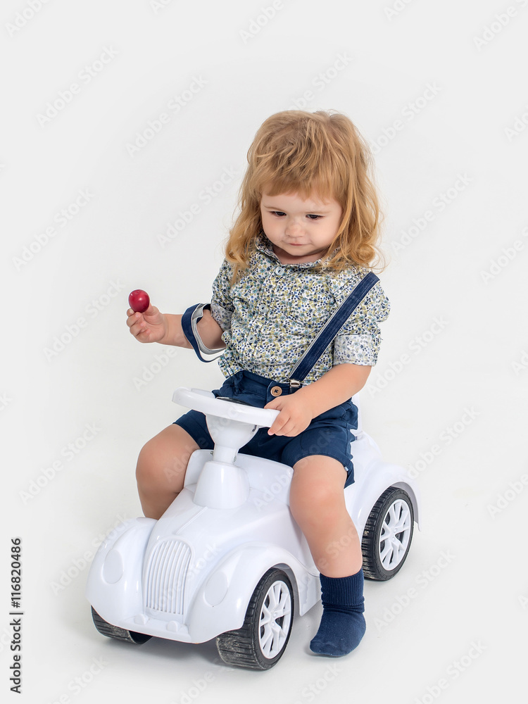 blonde small boy driver isolated on white