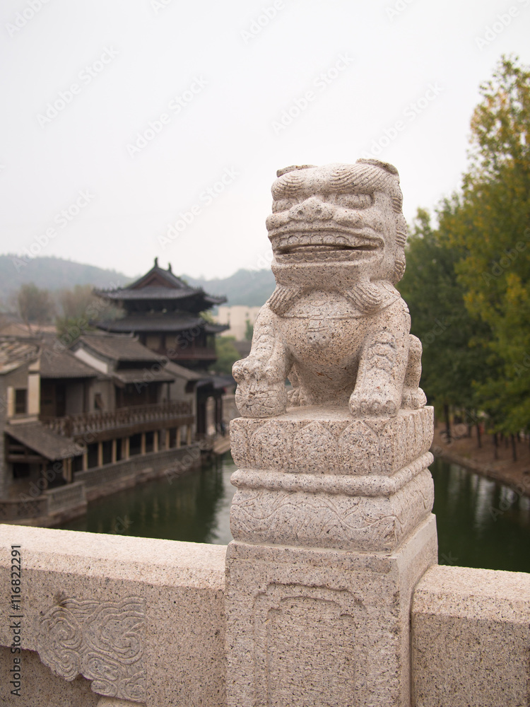 Obraz premium Statue of Chinese dragon on a background of the temple with water and trees
