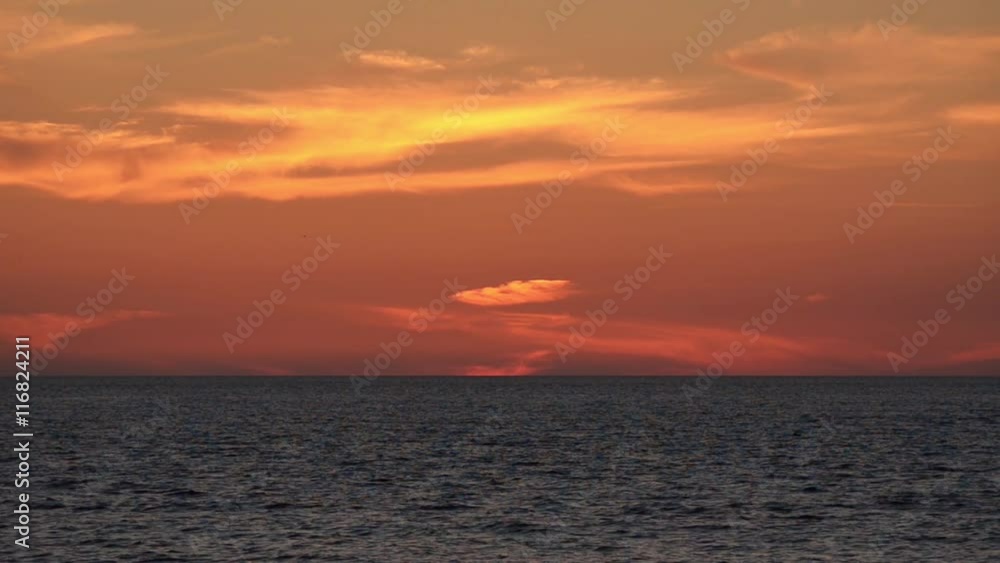 Beautiful sky with cirrus clouds and calm sea after sunset.
