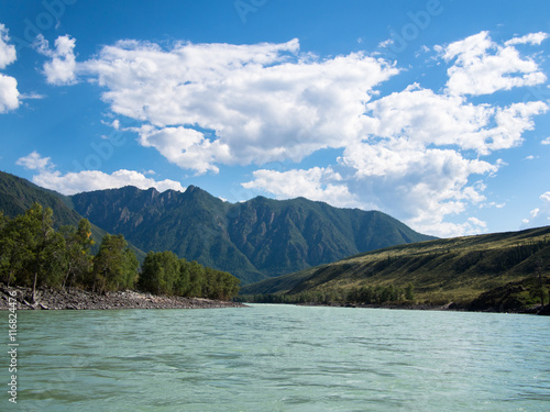 View of the wide river with mountains and trees against the sky with clouds © atomfotolia