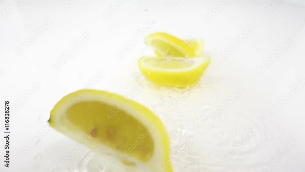 lemon splashing on water breaking in slices slow motion white background lemon splashing on water breaking in slices slow motion white background