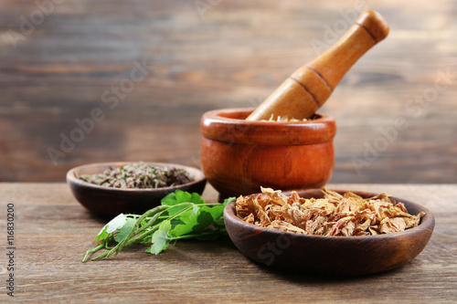 Natural flower and herb selection in bowls on wooden background