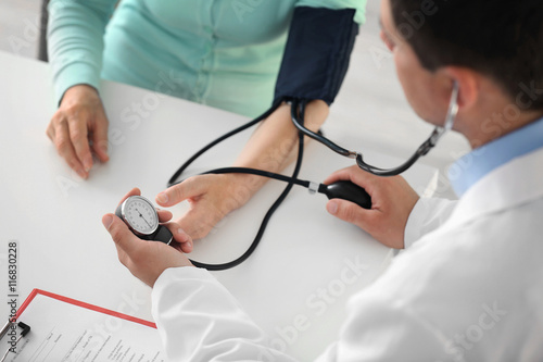 Male doctor measuring woman...