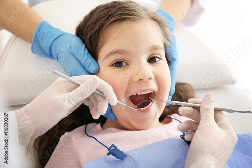 Dentist examining girl s teeth