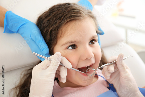 Dentist examining girl's teeth