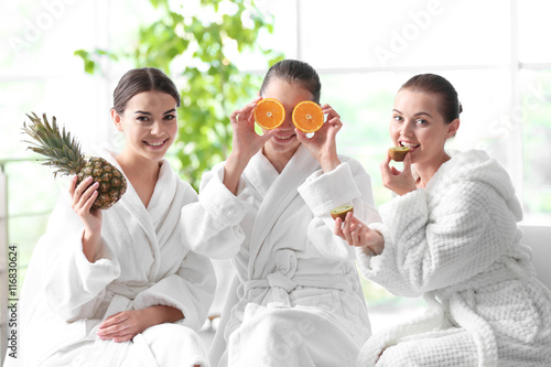 Beautiful girls with fruits in spa salon