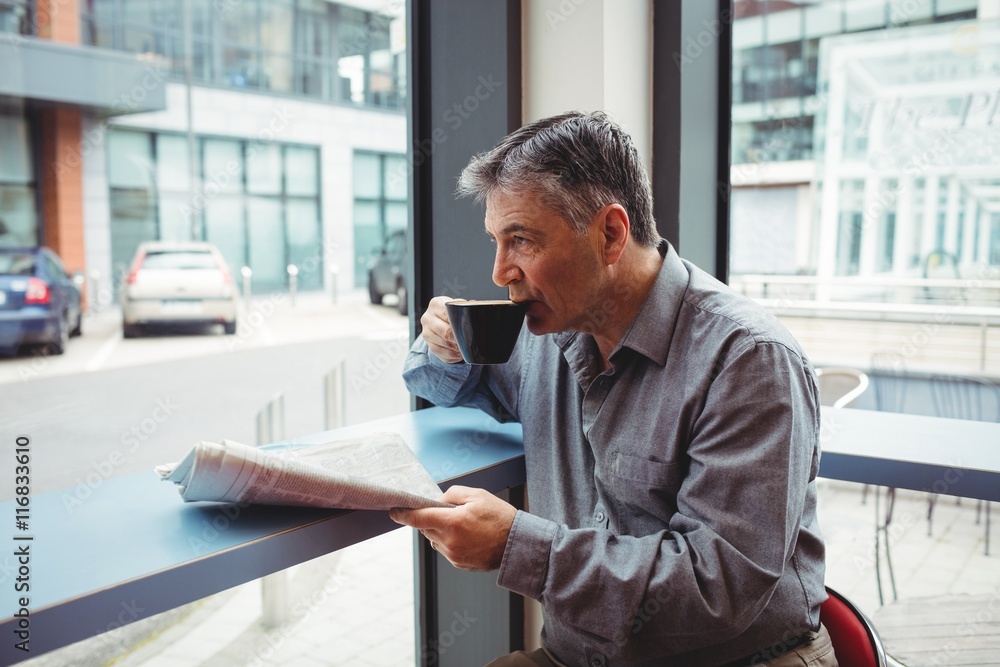 Man holding newspaper and having coffee Man holding newspaper and having coffee