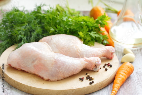 Raw chicken legs with vegetables ready for cooking